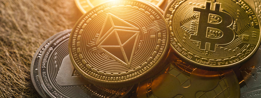 Bitcoin and other crypto coins together in a pile with gold lighting.