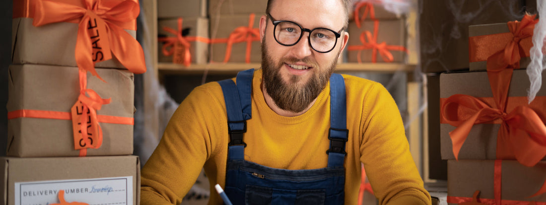 A man sits with a handful of boxes with orange bows.