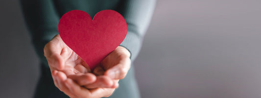 A woman holding a heart made of paper