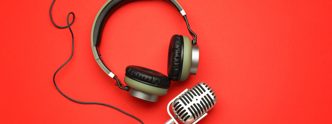 Podcast equipment on a red backdrop.
