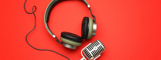 Podcast equipment on a red backdrop.