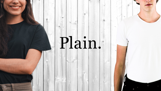 Woman wearing black on the left, man wearing white on the right, Plain logo in the center with a white wooden wall in the background.