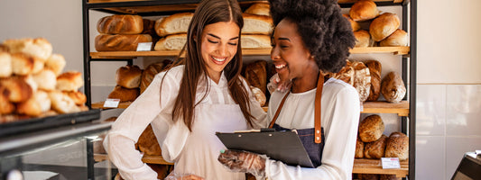 two small business owners talking in a bakery.
