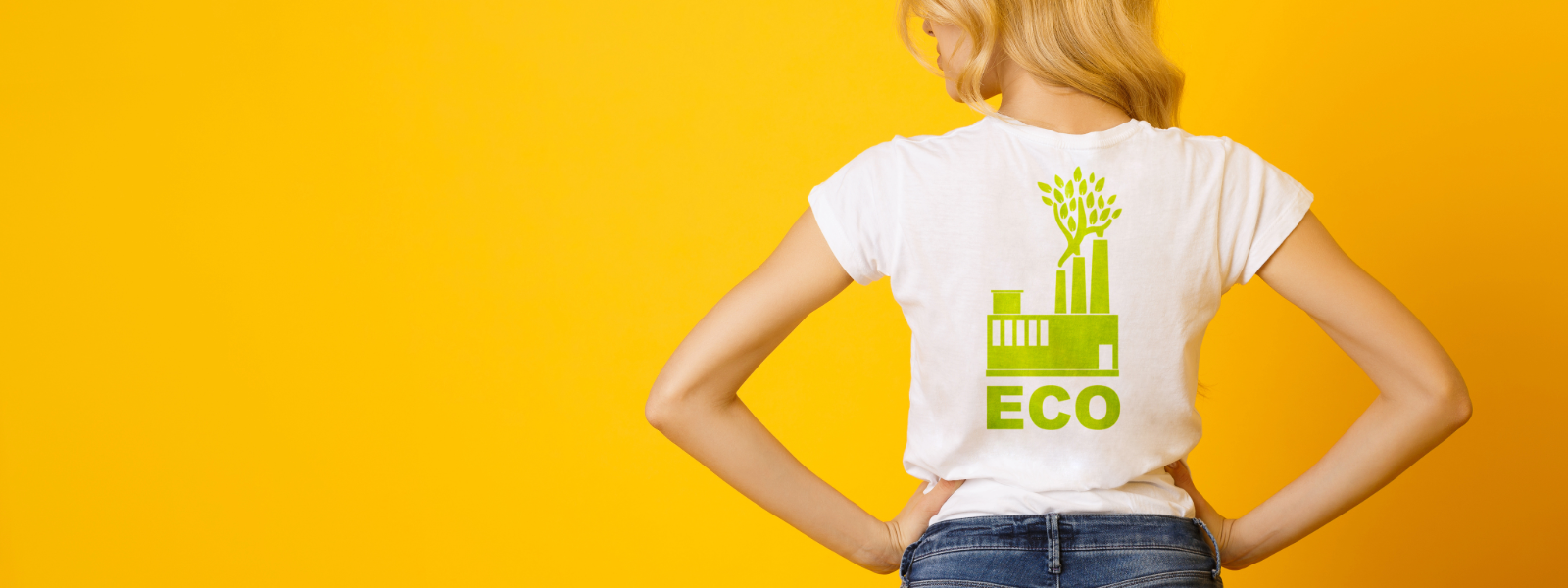 Woman wearing a white print designed t shirt with ECO on it in green and a eco friendly factory with leaves sprouting out of the stacks. On an orange background.