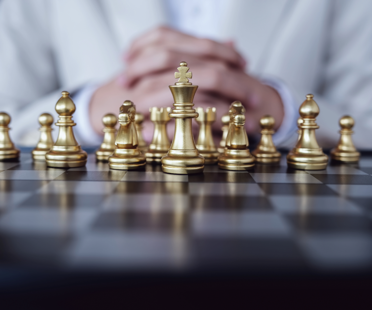 Golden chess pieces on a board with hands folded behind it ties to the strategic design narrative of this article.