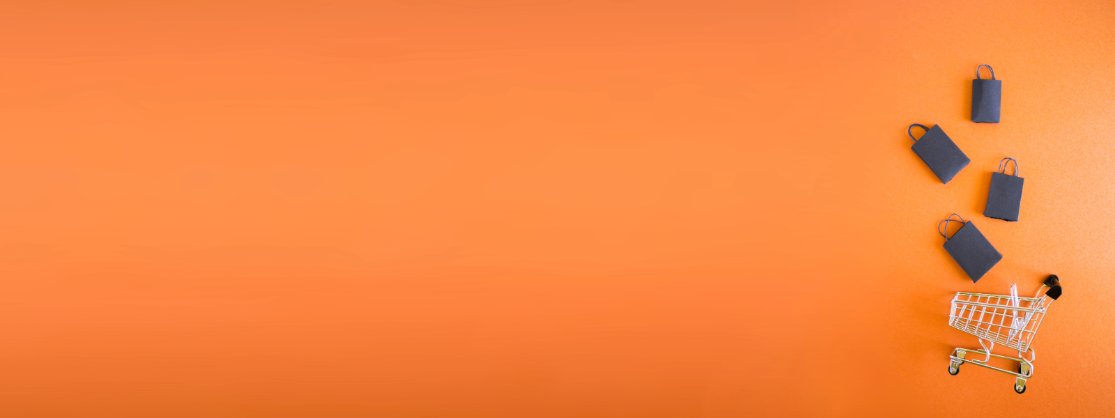 Orange background with a shopping cart that has black shopping bags falling into it.