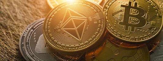 Bitcoin and other crypto coins together in a pile with gold lighting.