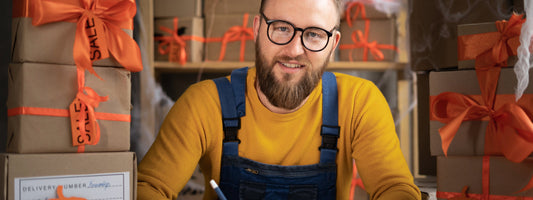 A man sits with a handful of boxes with orange bows.