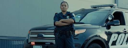 A female officer standing in front of her squad SUV.