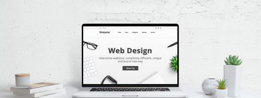 A white website design with a banner and CTA on a laptop screen in a white room.