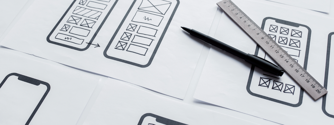 A paper with mobile wireframes drawn on it for website design.